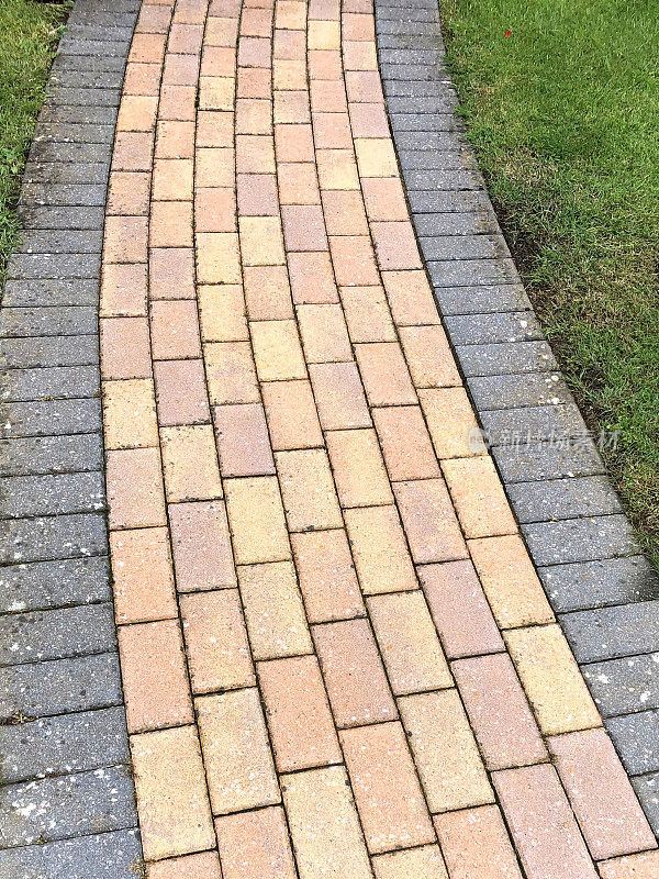 新红黄相间的砖砌小路，铺着灰色的石块，铺着花园小径