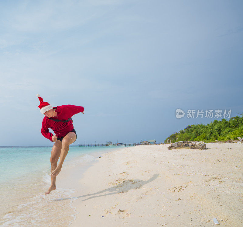 圣诞老人在马来西亚婆罗洲的太平洋沙滩上奔跑。