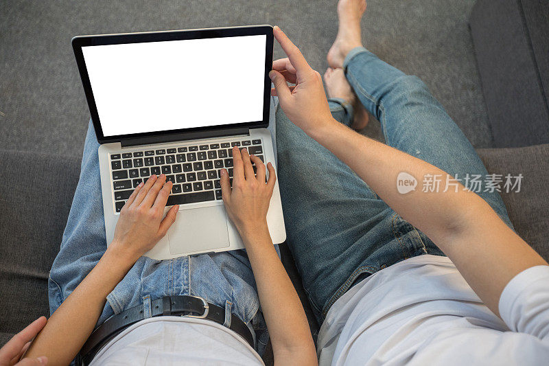年轻夫妇在客厅使用笔记本电脑