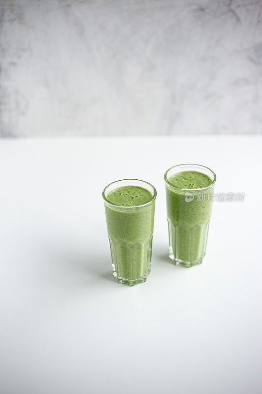 绿色排毒汁在白色大理石背景与复制空间。素食排毒的概念。