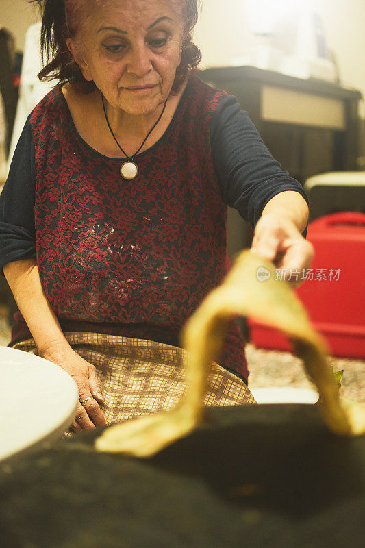 一个女人正在客厅里用电子设备做馅饼