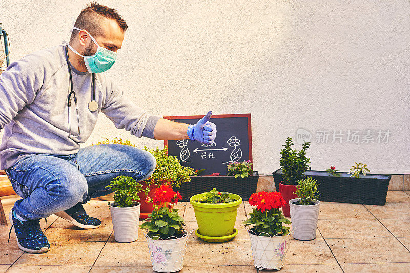 年轻的专业园丁戴着面具和手套照顾他的植物。园艺的概念。流行的概念。