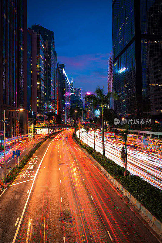 霓虹夜路，高速公路，高速交通穿过摩天大楼的城市景观香港