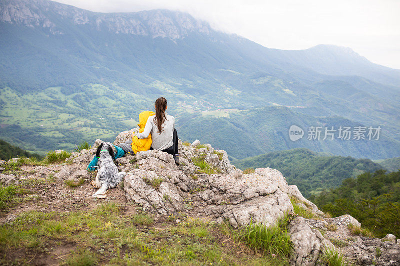 妈妈和儿子享受风景，同时与他们的狗