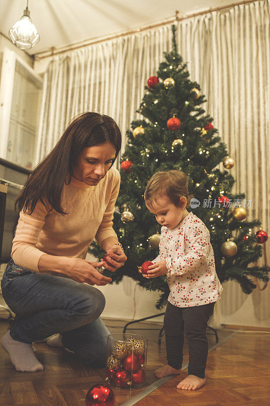 妈妈和她的小女儿一起装饰圣诞树