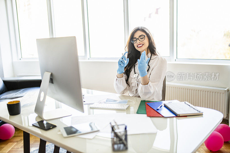 女医生使用洗手液和在办公室工作