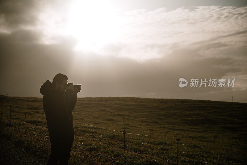 一个年轻人正在用单反相机拍照