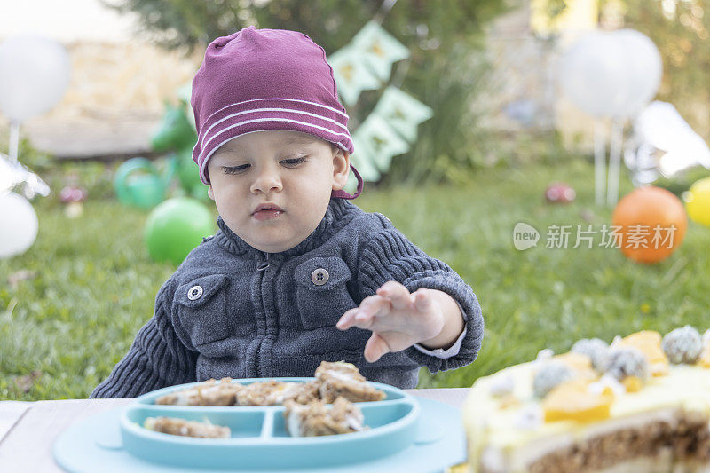 第一个生日。可爱的小男孩在花园里庆祝生日。