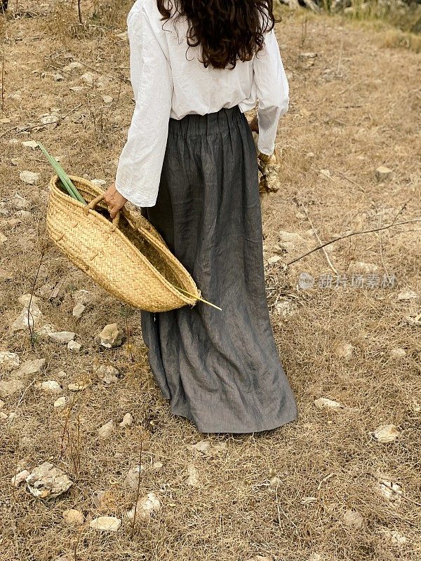 农妇穿好衣服，提着草篮去田野里散步