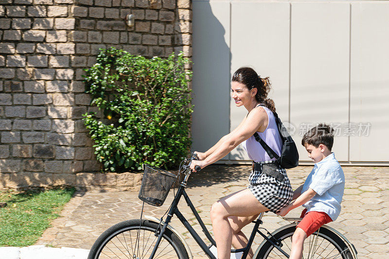 巴西母亲和儿子在一个阳光明媚的早晨悠闲地骑着自行车。