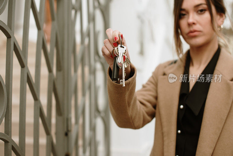 年轻的女人手里拿着新房子的钥匙