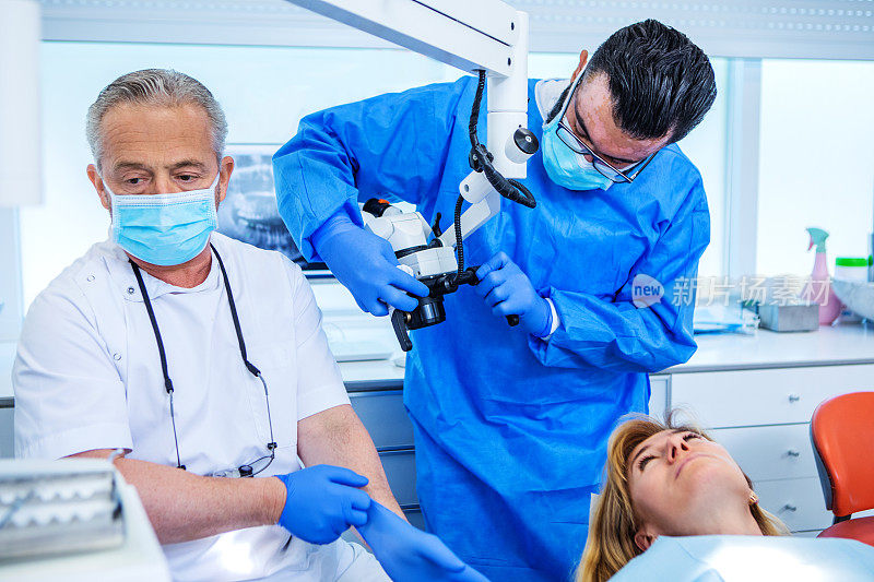 牙科医生在牙科手术中为病人治疗的牙医和助手