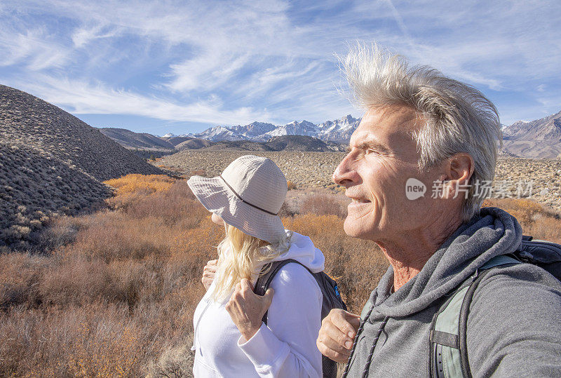 一对徒步旅行的夫妇沿着小路穿过干旱的沙漠