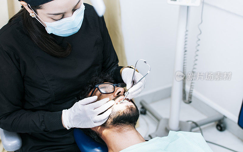 牙科医生给病人检查牙套，病人由牙科医生检查，牙科医生进行牙科检查