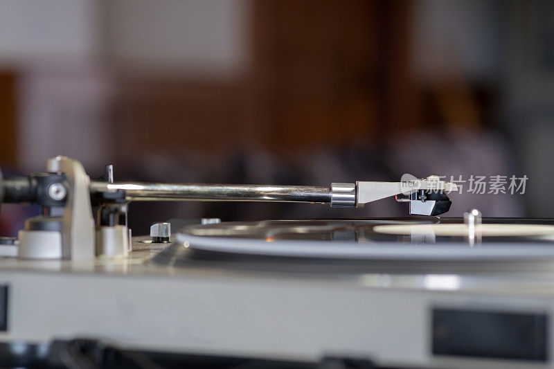 专注于头壳卡带和手写笔的经典复古黑胶唱片播放器或唱机播放黑胶唱片音乐