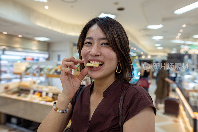 一名女子在机场品尝食物纪念品