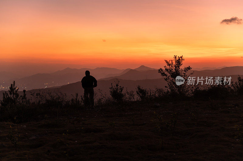 黄昏时，红艳艳的晚霞漫天，一个人的背影就在山上