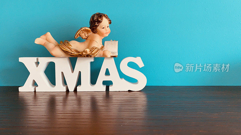 单词圣诞和阅读天使在蓝色的背景