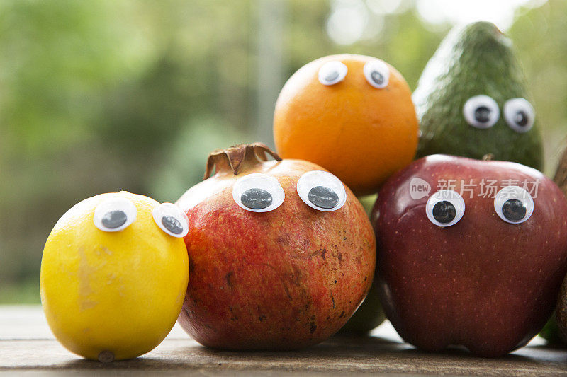 柠檬，石榴，橙子，鳄梨和红苹果的眼睛，有趣的新鲜水果概念