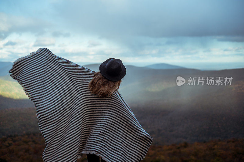 年轻女子徒步穿越美丽的山脉。