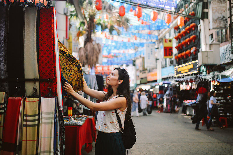 年轻的旅行者女人在吉隆坡唐人街区购物