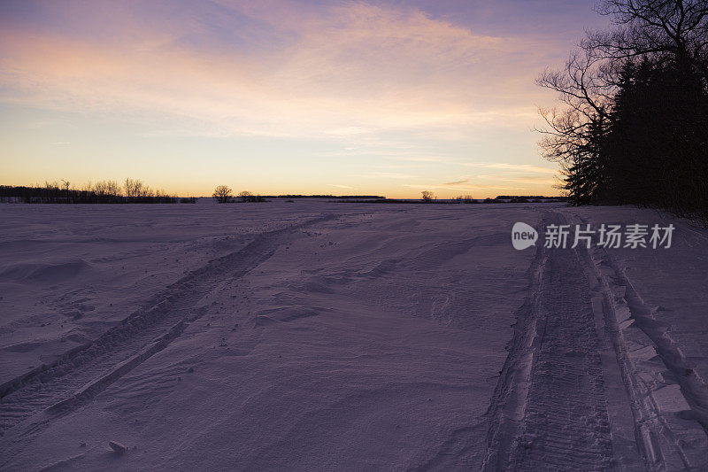 日落时的雪地摩托轨迹