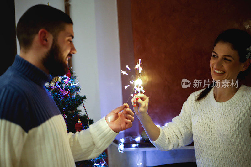 圣诞快乐。年轻夫妇在家庆祝圣诞节