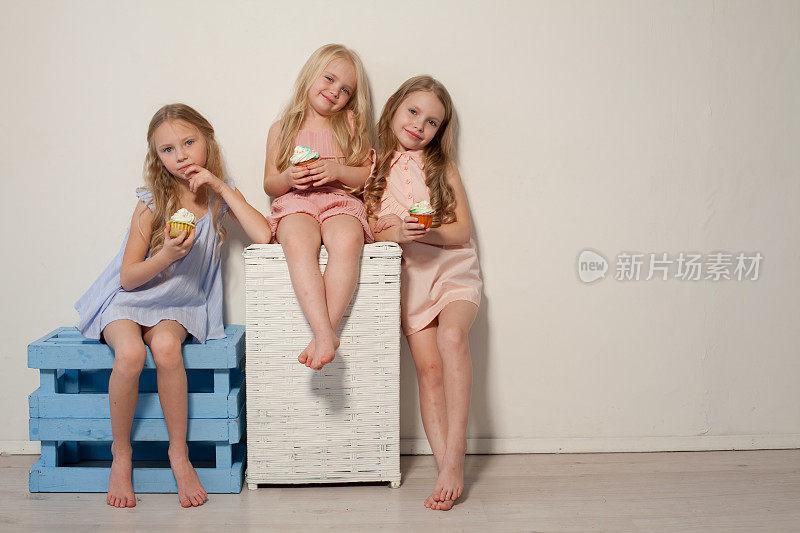 吃糖果棒棒糖的三个金发小女孩