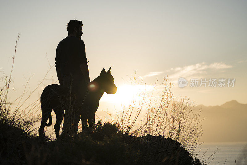 日落时分，一个男人和他的狗