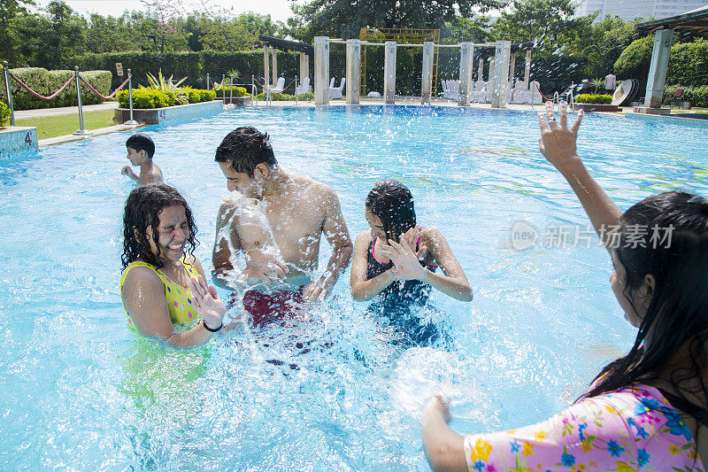 一群青少年朋友在游泳池里玩-股票形象