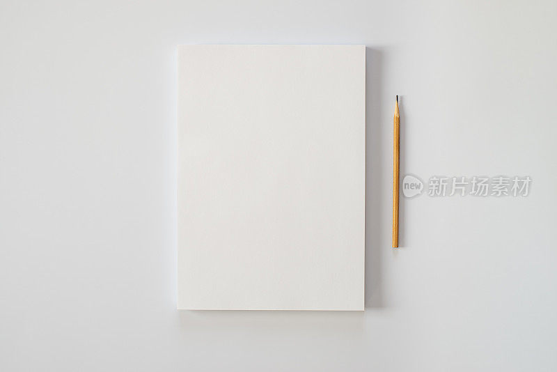 白色背景上的一叠白纸和一支铅笔。创作危机或一部新小说的开始。