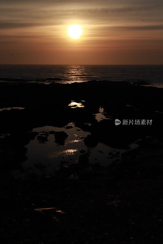 日出越过岩石和大海