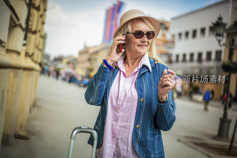 年长的女人带着旅行箱准备旅行