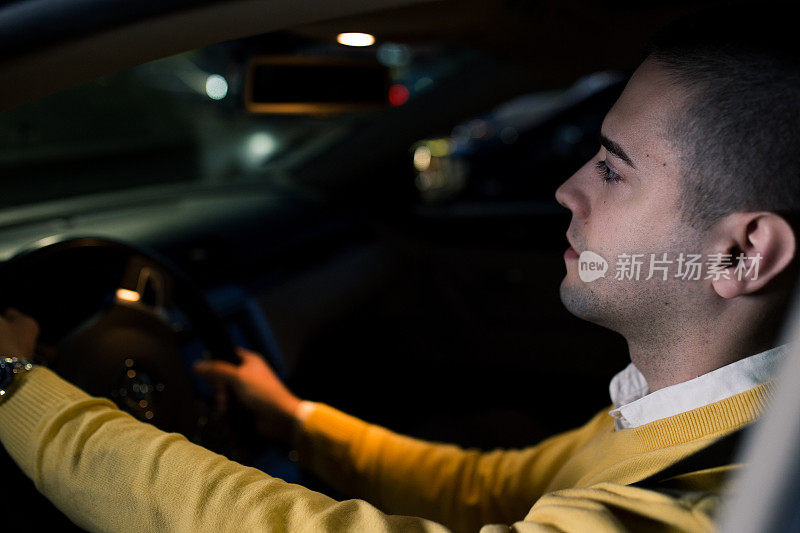 年轻时髦的男人在晚上开车