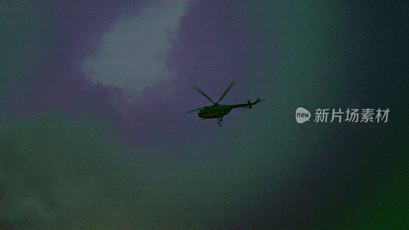 直升机在黑暗的天空中飞行。保安摄像机视图