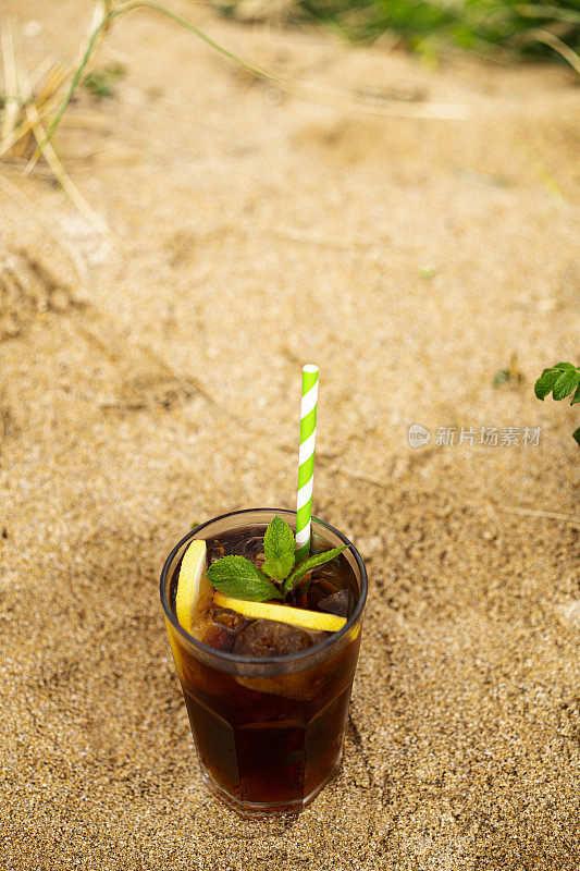 夏日的海滩上，一杯薄荷柠檬冰茶。