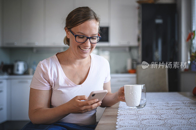 中年女性在厨房使用智能手机
