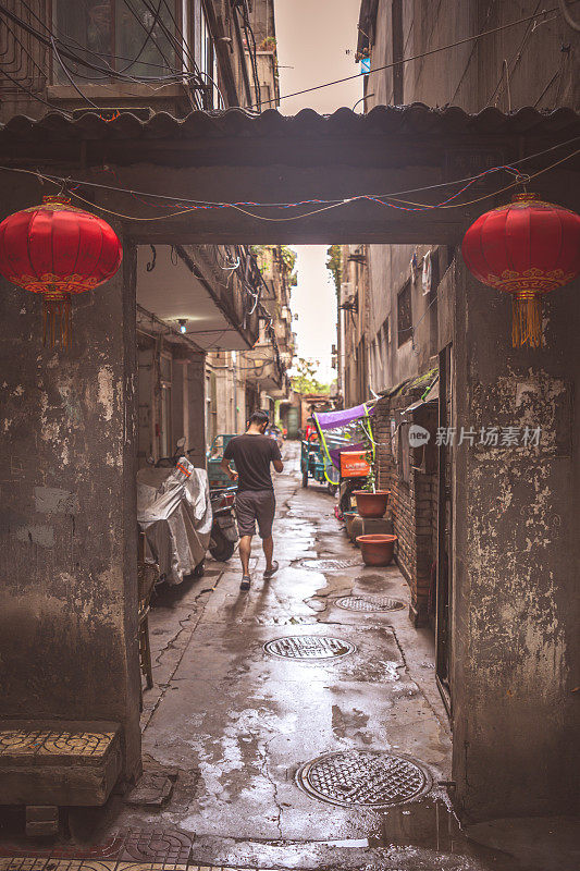 一名男子走在西安老城区狭窄的街道上