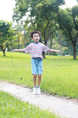 小男孩在草地上跳绳