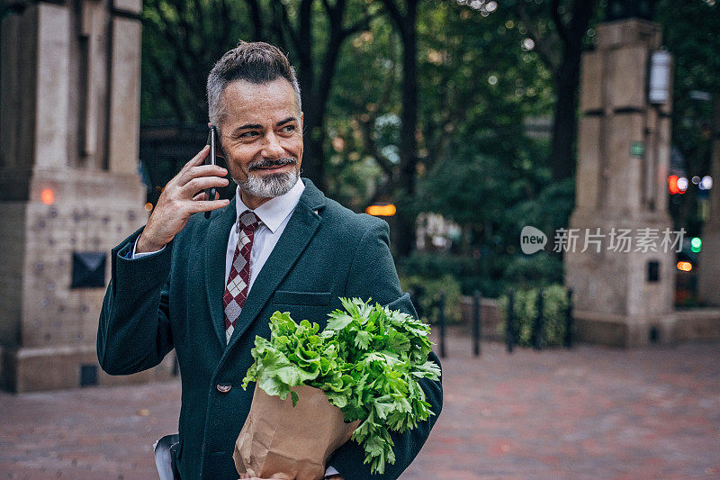 拿着购物袋打电话的男士