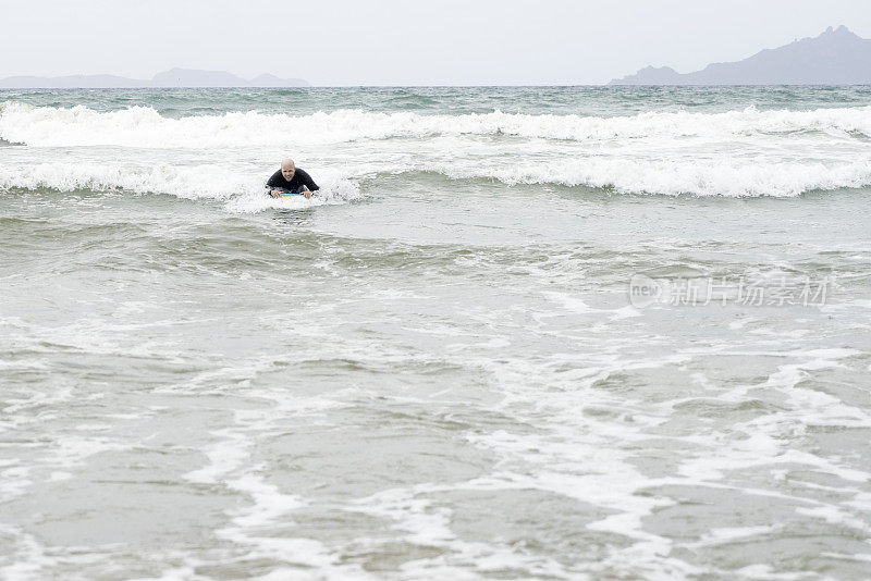 成年男性喜欢在冲浪海滩上玩人体滑板