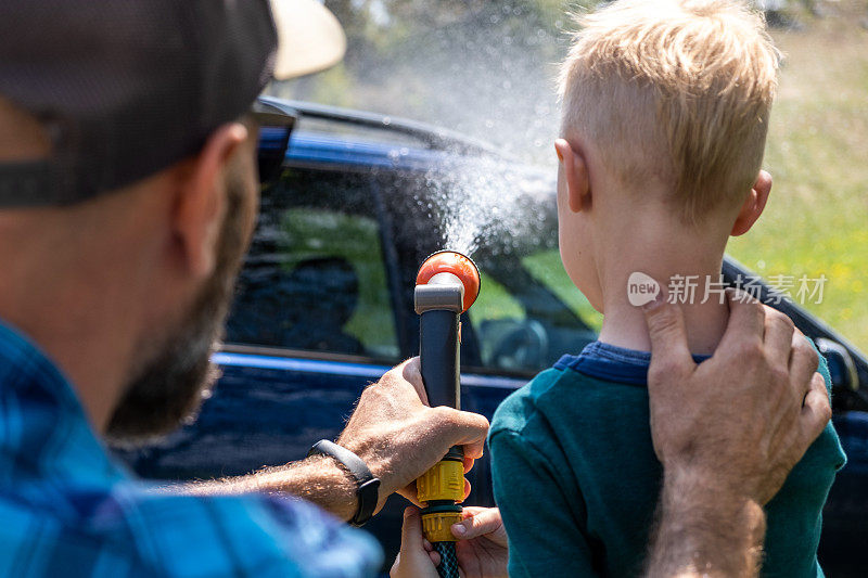 小男孩在爸爸的帮助下洗车