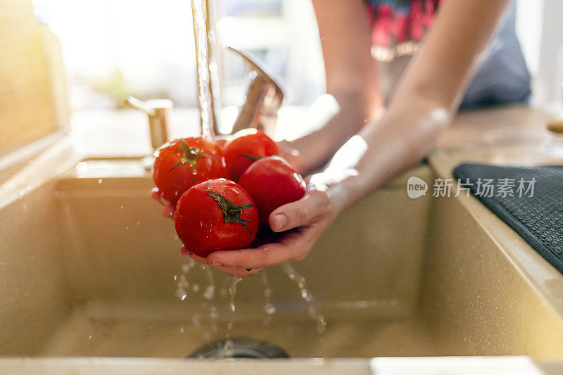 在厨房里用自来水洗蔬菜