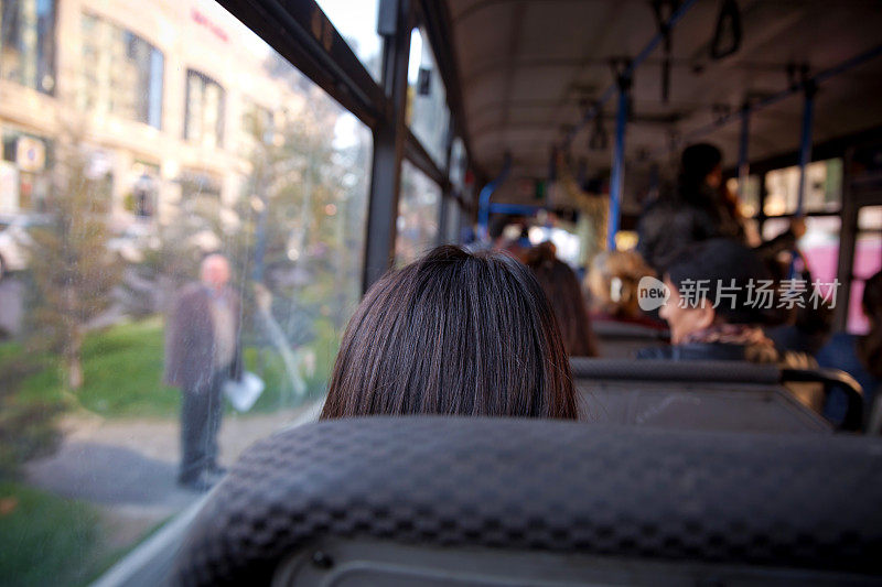 公共汽车是主要的公共交通乘客。人们在旧公交车上，从公交车里看。人们坐在一个舒适的公共汽车选择焦点和模糊的背景。