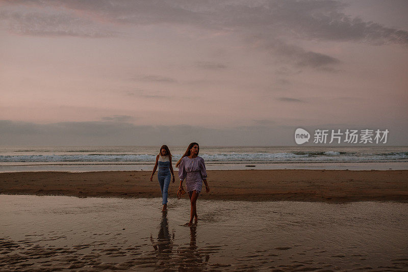 两个年轻女人在海滩上散步