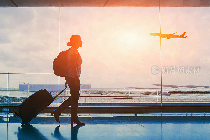 游客前往国际机场候机楼，看到一名女乘客的剪影