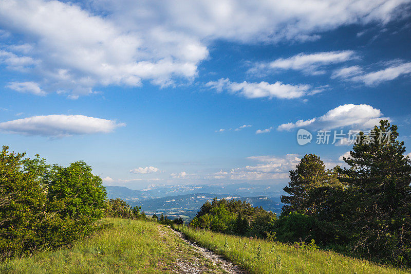 春天晚些时候，在法国阿尔卑斯山脉中间的山顶上，徒步旅行的泥泞小径