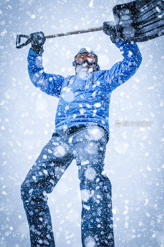 在暴风雪中戴着护目镜和铲子的人