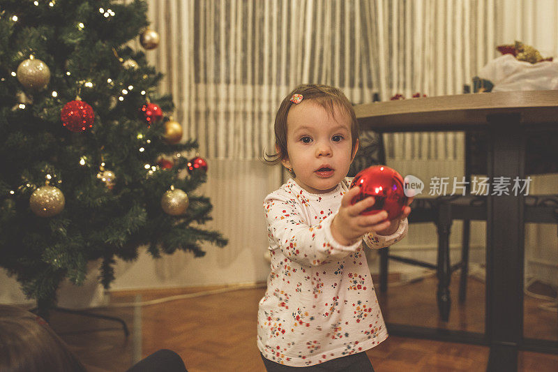 小女孩在镜头前展示她最喜欢的圣诞装饰品