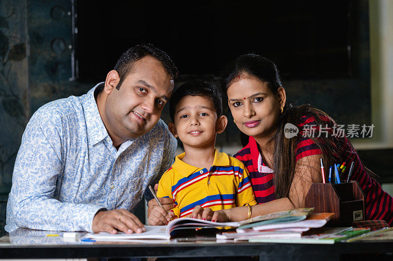 父母在家里帮助儿子学习和完成家庭作业。